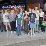Grupa uczniów stoi w wejściu do kina.