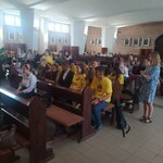 Uczestnicy przeglądu siedzą w ławkach w kościele.