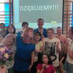 Pani Iza z bukietem kwiatów w otoczeniu nauczycieli i uczniów.