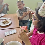 Uśmiechnięci uczniowie siedzą przy stole.
