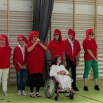 Występ artystyczny- siedem osób w czerwonych strojach przebranych za krasnoludki.Przed nimi dziewczynka na wózku w przebraniu królewny.