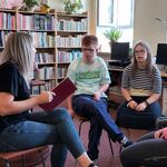 Nauczycielka czyta uczniom książkę w bibliotece.