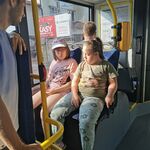 Uczennice siedzą obok siebie na siedzeniach w autobusie.