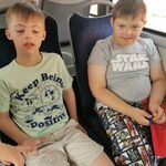 Uczniowie siedzą obok siebie na siedzeniach w autobusie.
