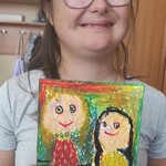 Dziewczynka prezentuje kartkę otrzymaną od koleżanki z okazji urodzin.