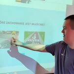Uczeń na tablicy multimedialnej wskazuje poprawne/ niepoprawne zachowanie na drodze.
