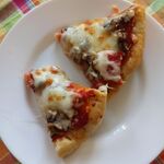 Dwa kawałki pizzy na talerzu.