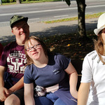 Dwóch chłopców i dwie dziewczynki siedzą na ławce i czekają na autobus powrotny do szkoły.