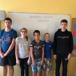 Grupa uczniów stoi przed białą tablicą