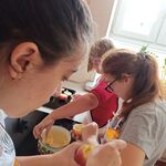 Uczniowie nadziewają jabłka budyniem.