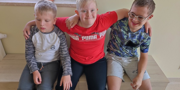 Trzech chłopców siedzi na skrzyni