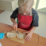 Dziewczynka smaruje chleb masłem