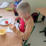 Dwóch chłopców siedzi przy stole, przygotowują kanapki