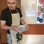 Uczeń z talerzami w rękach.