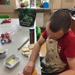 Uczeń wyjmuje plasterek sera z opakowania.