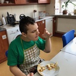 Uczeń siedzi przy stole. Przed nim stoi talerz z resztkami tostów.