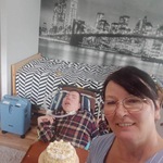 Mama chłopca na pierwszym planie, na drugim planie chłopiec na wózku  z tortem
