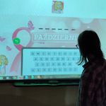 Uczennica na tablicy multimedialnej rozwiązuje zadanie.
