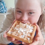 Uczennica je gofra z bita śmietaną.