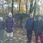 Uczniowie stoją na tle pomnika poświęconego pamięci bohaterów podziemia.