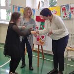 Nauczycielka wręcza nagrodę uczestniczce konkursu.