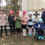 Grupa uczniów na tle pomnika nieznanego żołnierza.