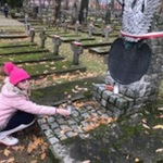 Uczennica stawia znicz na grobie nieznanego żołnierza.