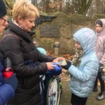 Nauczycielka i uczniowie ze zniczami.
