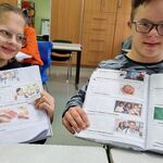 Uczeń i uczennica z otwartymi zeszytami.