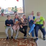 Pięcioro uczniów siedzi na ławeczce. Wszyscy trzymają w rękach laurki i słodycze.