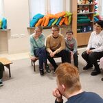 Grupa uczniów siedzi na ławkach.