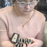Uczeń trzyma w rękach statyw do aparatu.