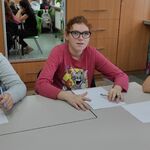 Uczennice siedzą przy stole. Przed nimi leżą odwrócone kartki z testem.