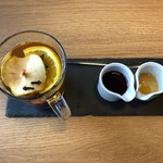Herbata w kubeczku. Obok dodatki w dzbanuszkach.