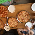 Stół na którym stoją duże pizze.