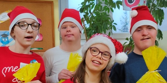 Uczniowie stoją z prezentami od Mikołaja