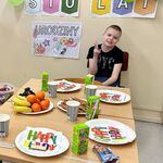 Uczeń siedzi przy stole, pozuje do zdjęcia.