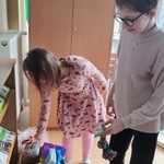 Uczennice wkładają  do kartonu rzeczy dla zwierząt przyniesione przez uczniów.