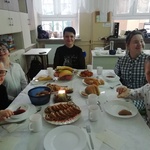 Grupa uczniów siedzi przy wigilijnym stole.