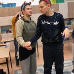 Uczniowie w karnawałowych opaskach trzymają się za rękę.
