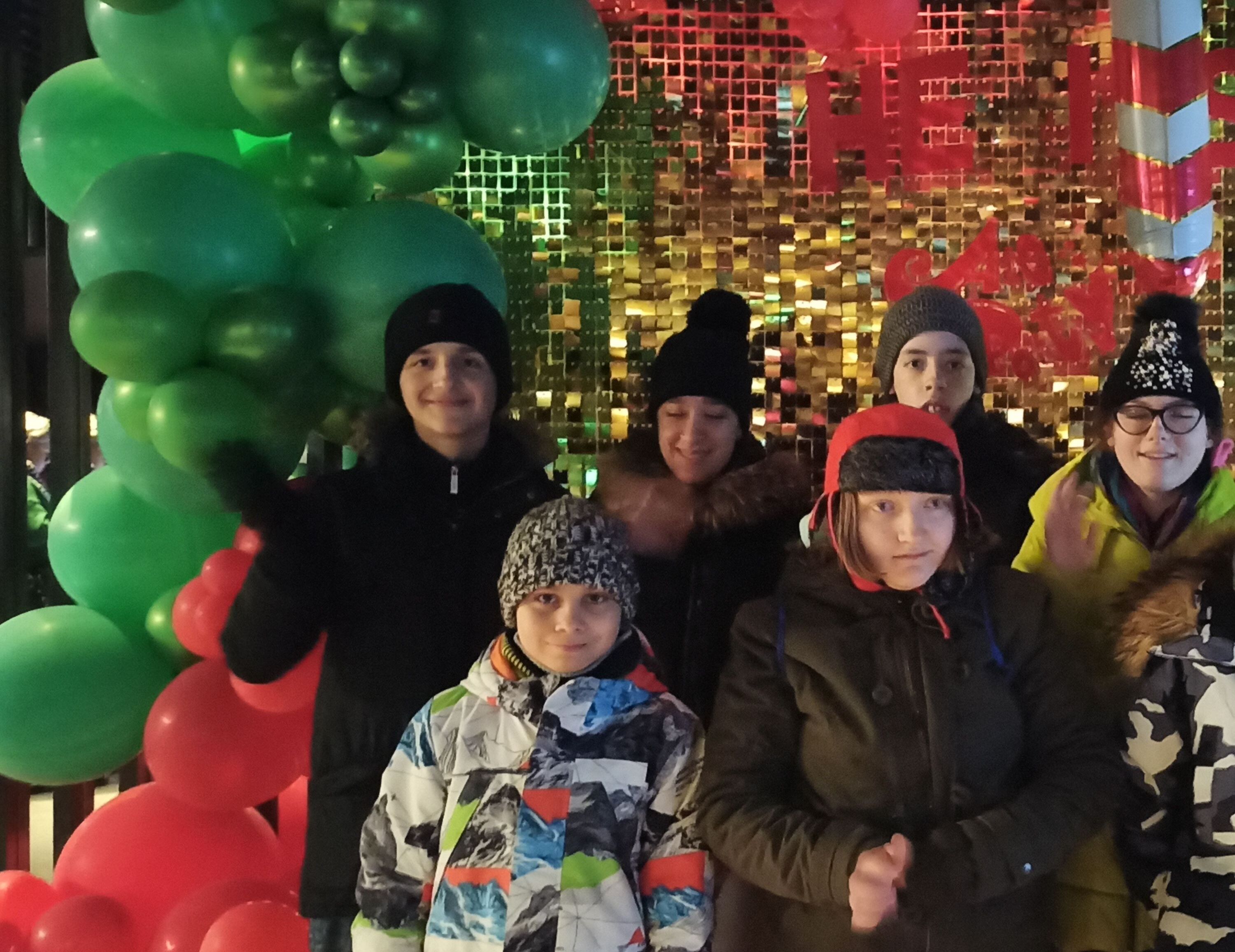 Uczniowie pozują do wspólnego zdjęcia na tle ścianki karnawałowej.