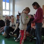 Uczennica wybiera odblask z torebki trzymanej przez nauczycielką.