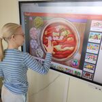 Uczennica układa puzzle - pizzę na tablicy interaktywnej.
