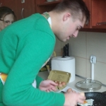 Uczeń wbija jajko na patelnię.