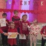 Grupa uczniów z obrazkami związanymi z Walentynkami.