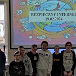 Uczniowie biorący udział w spotkaniu na tle ekranu z wyświetlanym slajdem Bezpieczny internet 19.02.2024.