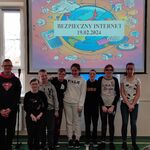 Uczniowie biorący udział w spotkaniu na tle ekranu z wyświetlanym slajdem Bezpieczny internet 19.02.2024.
