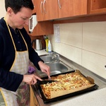 Nauczycielka kroi nożem pizzę.
