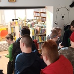 Uczniowie stoją w bibliotece.