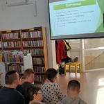 Uczestnicy zajęć w bibliotece oglądają prezentację.